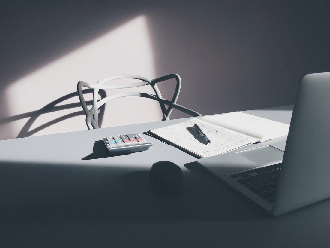 A desk with a laptop and calculator